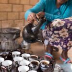 A woman pouring coffee from a jebena during an Ethiopian coffee ceremony